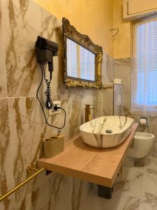 a bathroom with a sink and a mirror on the wall at PRINCIPE ROOMS in Rodigo