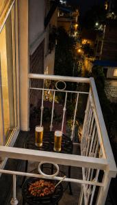two glasses of beer and a pizza on a balcony at Beautiful Kathmandu Swimming pool Hotel in Kathmandu