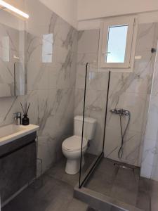 a bathroom with a toilet and a shower and a sink at OLIVE & SEA in Nea Moudania +15 photos