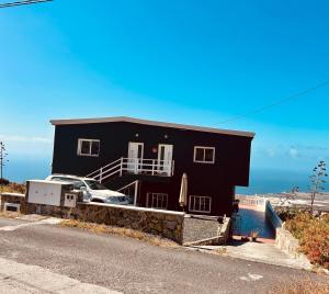 a black house with a car parked in front of it at Vista Guapa in Frontera