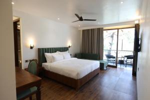 a hotel room with a bed and a table at Ventus Pines in Kasauli