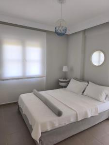 a bedroom with a large white bed with a window at OLIVE & SEA in Nea Moudania