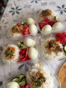 four plastic containers of food with rice and vegetables at Kausar in Kalīnīno