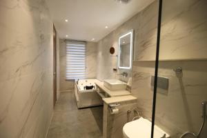 a bathroom with a sink and a toilet and a mirror at Ventus Pines in Kasauli