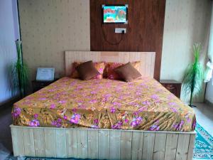 a bedroom with a large bed with flowers on it at Routelahomestay in Gangnāni