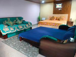 a living room with two beds and a couch at Routelahomestay in Gangnāni