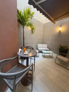 eine Terrasse mit Tisch und Stühlen und einer Palme in der Unterkunft Kadiss Hotel in Dakar + 97 Fotos