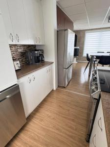 eine Küche mit Kühlschrank und einem Tisch mit Stühlen in der Unterkunft Azura in Roberval