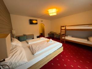 a room with two bunk beds and a red carpet at Sidan Hotel Restaurant & Pizzeria in Schwendau