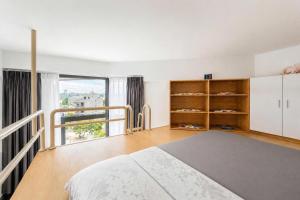 a bedroom with a bed and a large window at Savia Home in Danang