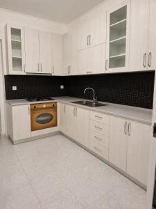 a kitchen with white cabinets and an orange sink at Dagos Rooms in Dhërmi +42 photos