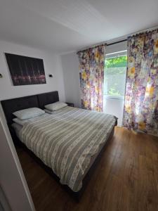 a bedroom with a bed and a window with curtains at Resort Marina Suchacz in Suchacz