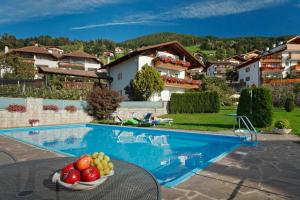 a bowl of fruit on a table next to a swimming pool at Haus Bernhard in Schenna