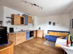a kitchen and a living room with a blue couch at Haus Bernhard in Schenna
