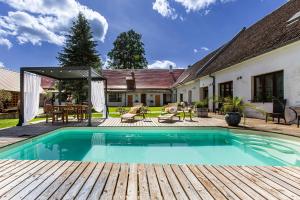 a house with a swimming pool and a wooden deck at Resort Biskupský Dvůr in Višňová