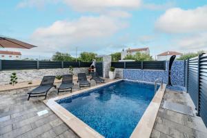 a swimming pool on a roof with chairs next to it at Villa Lukas in Nin