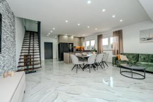 a living room with a table and chairs and a kitchen at Villa Lukas in Nin