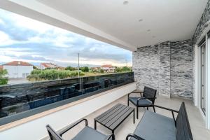 a balcony with chairs and a large window at Villa Lukas in Nin