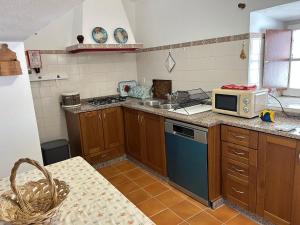 a kitchen with a stove and a microwave in it at Casa Grande do Monte in Mértola +8 photos