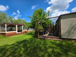 a backyard with a house and green grass at Resort Marina Suchacz in Suchacz