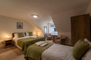 a hotel room with two beds and a chair at White Swan Hotel in Alnwick