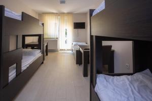 a room with three bunk beds and a desk at Fürdőkerti Ifjúsági Szálló in Hajdúböszörmény