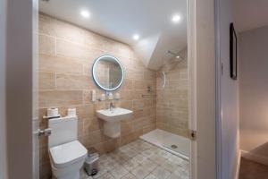 a bathroom with a toilet and a sink and a mirror at White Swan Hotel in Alnwick