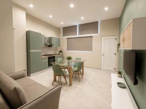 a kitchen and living room with a table and a couch at Maison Sicilienne in Turin