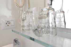 a shelf with a bunch of glass vases on it at Apartments and Rooms Oliva in Cres +94 photos