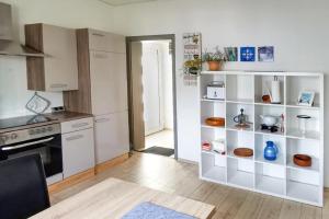 a kitchen with a white shelving unit in a room at NEU! FeWo Moritz OG in Selters +7 photos