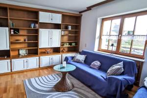 a living room with a blue couch and a table at NEU! FeWo Moritz OG in Selters