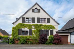 a white house with green ivy on it at NEU! FeWo Moritz OG in Selters
