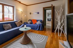 a living room with a blue couch and a table at NEU! FeWo Moritz OG in Selters