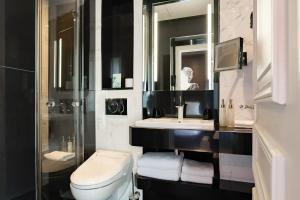 a bathroom with a toilet and a sink and a mirror at Maison Albar- Le Champs-Elysées in Paris +121 photos