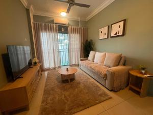 a living room with a couch and a tv at LS homestay Ipoh in Chemor
