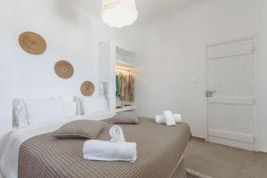 a white bedroom with a large bed with towels on it at Bonatsa House in Agios Georgios +29 photos
