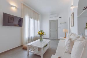 a white living room with a vase of flowers on a table at Bonatsa House in Agios Georgios