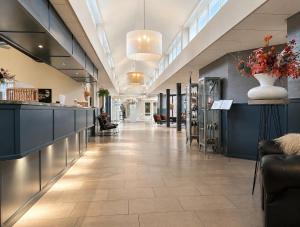 a lobby of a pharmacy with blue cabinets and flowers at Hotel De Werelt Garderen in Garderen