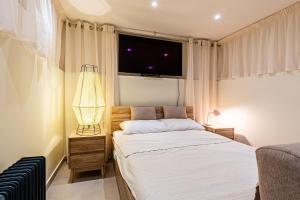 a bedroom with a bed and a tv on the wall at Room in Historic Knights House at the Marina in Senglea