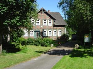 une grande maison en briques avec une route devant elle dans l'établissement Landhotel Sonnenhof im Wendland, à Clenze