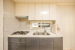 a kitchen with white cabinets and a sink at Eunpyeong St Mary's Hospital Yeonsinnae Station 3R3B Bukhansan 인사동 Namsan DDP 동대문 명동 Itaewon 20 mins in Seoul +78 photos
