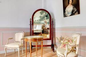 a room with a mirror and a table and chairs at Maison D'hôtes Saint-Gildas in Beaufort-en-Vallée