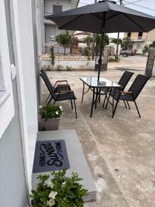 a patio with a table and chairs and an umbrella at Fabio apartment in Amarynthos
