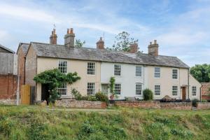 a large white house with a brick building at Westport Cottage in Wareham