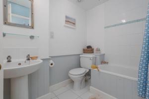 a white bathroom with a toilet and a sink at Westport Cottage in Wareham +38 photos