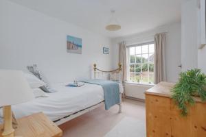 a bedroom with a bed and a window at Westport Cottage in Wareham