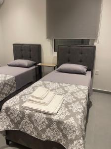 two beds in a room with towels on them at Fabio apartment in Amarynthos