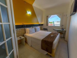 a hotel room with a bed and a window at Ibis Budget Salvador in Salvador