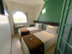 a hotel room with two beds and a window at Ibis Budget Salvador in Salvador +79 photos
