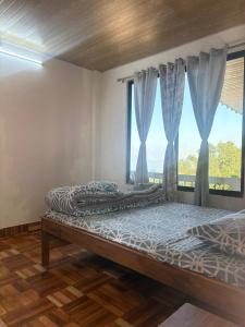 a bedroom with two beds and a window at Bikash Homestay in Mangpu